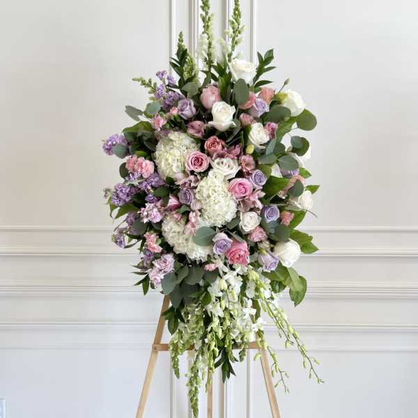 Large pastel floral spray on a wooden easel