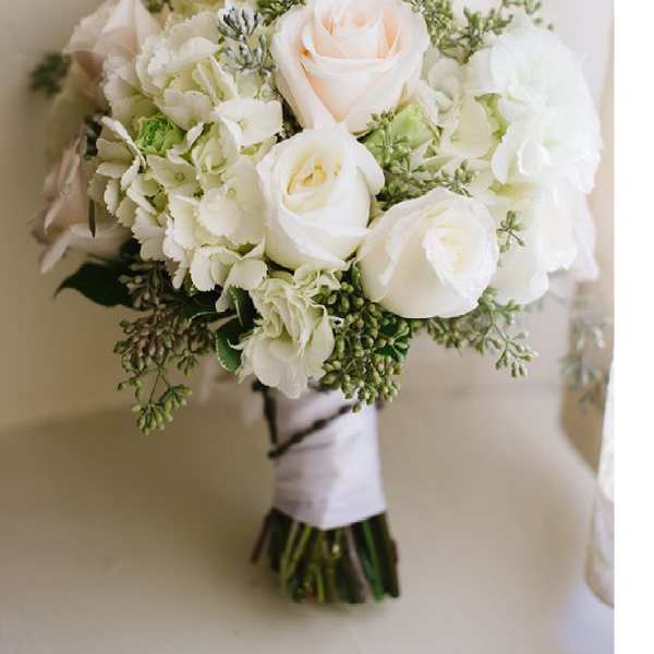 White rose bouquet with pale hydrangeas and greenery