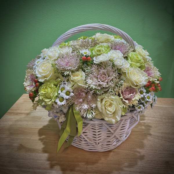Basket arrangement of cream roses and small white daisies