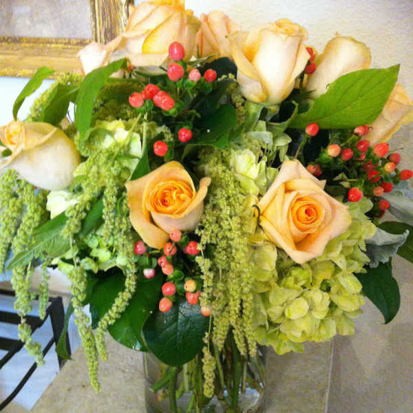 Peach roses and green hydrangeas in a glass vase