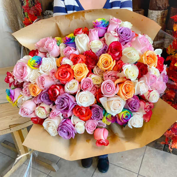 Large bouquet of multicolored roses wrapped in brown paper