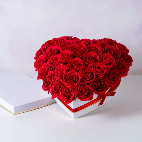 Heart-shaped box of red roses with a matching lid beside it