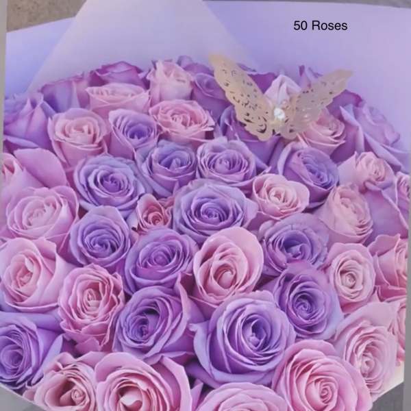 Bouquet of pink and purple roses with a butterfly topper