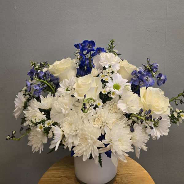 White and blue flower arrangement in a white vase