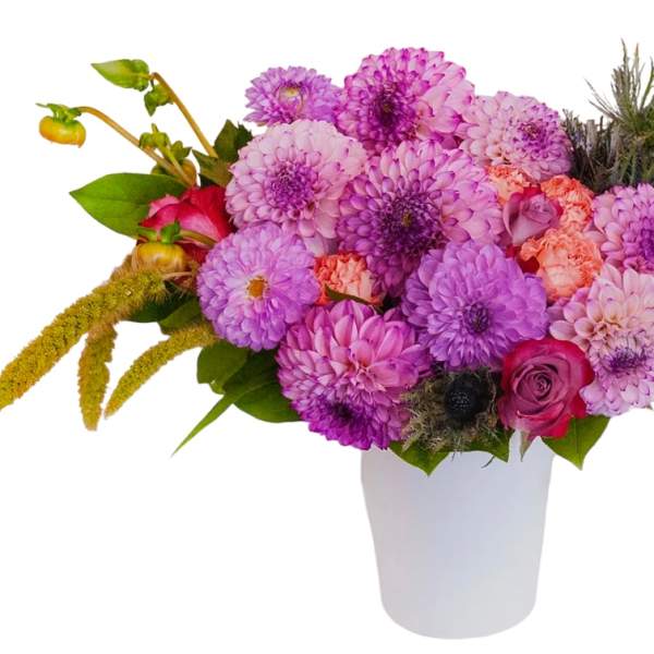 Pink and purple bouquet in a white vase with a few roses and textured blooms