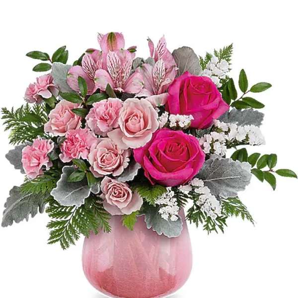 Pink rose bouquet in a pink glass vase with silver foliage