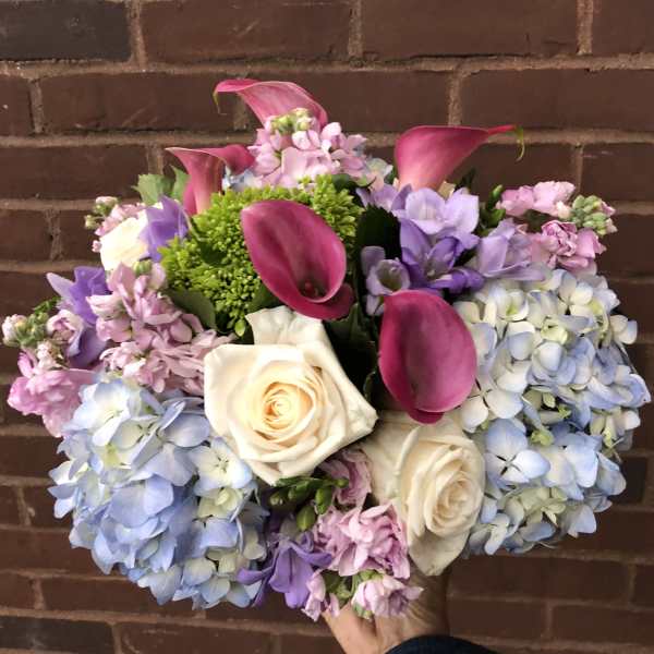 Bouquet of pink calla lilies, white roses, and blue hydrangeas