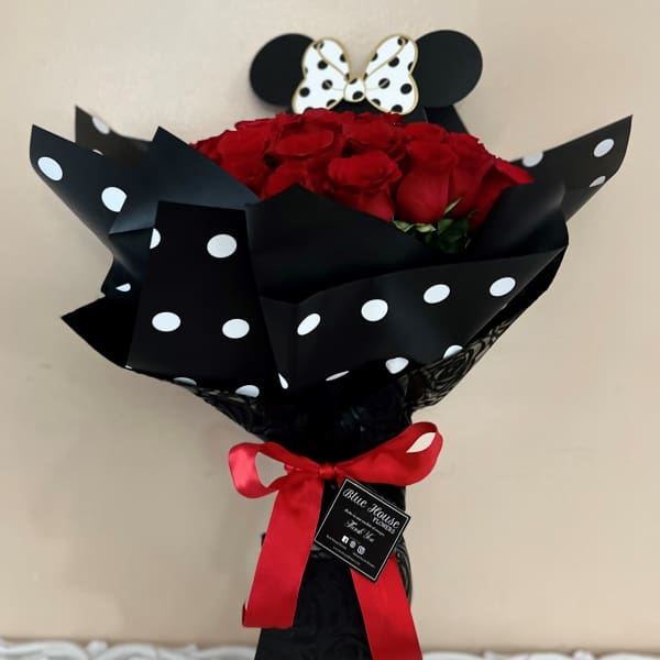Bouquet of red roses wrapped in black polka-dot paper with a red ribbon