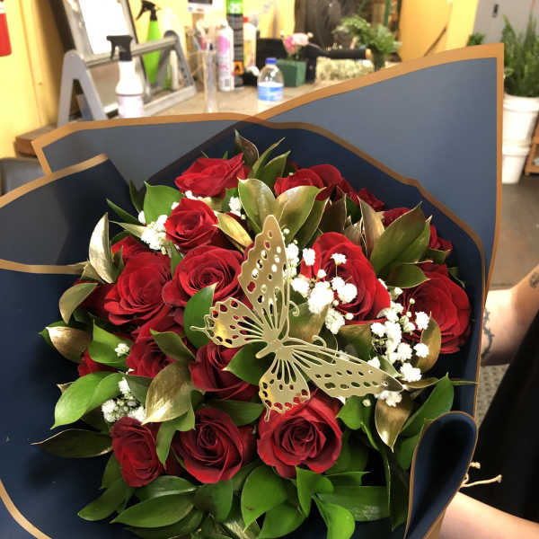Bouquet of red roses with white filler and a butterfly decoration
