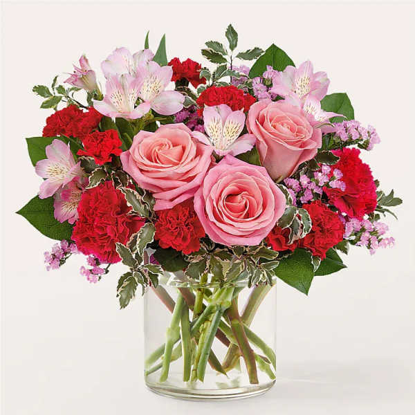 Pink roses and red carnations in a clear glass vase