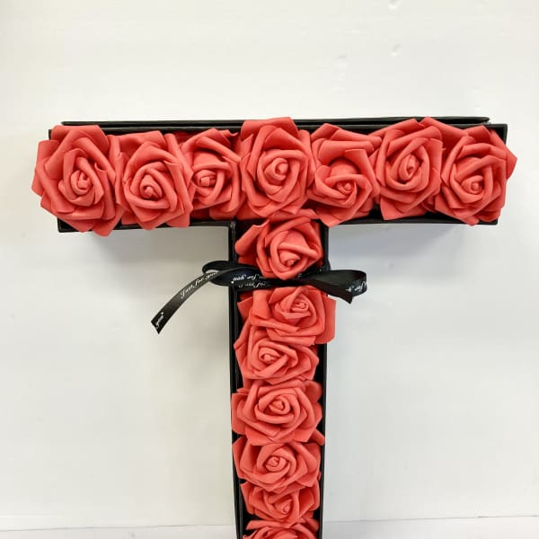 T-shaped box arrangement of coral roses with a black ribbon bow