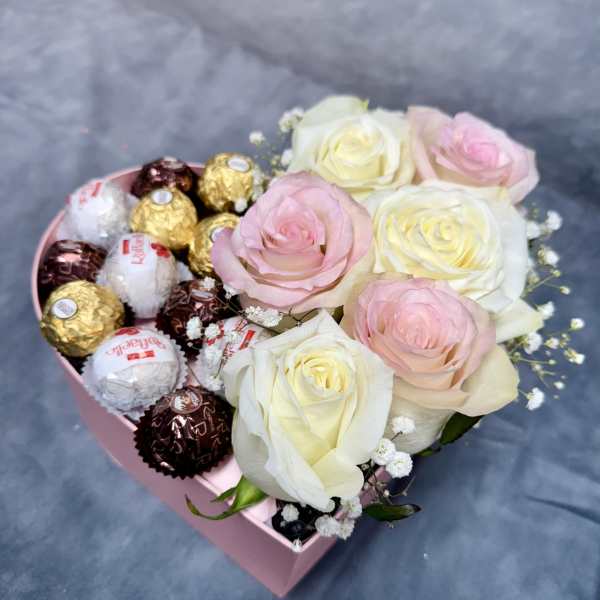 Pink heart-shaped box with roses and assorted chocolates