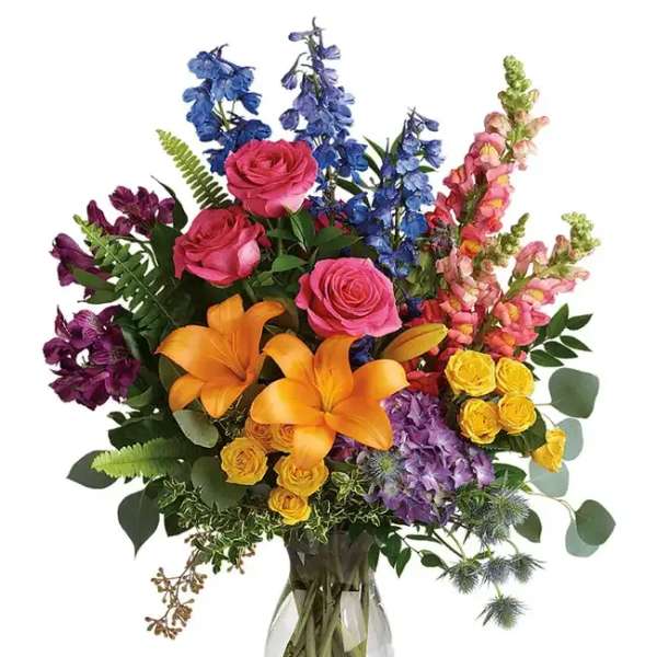 Colorful bouquet of roses, lilies, and snapdragons in a glass vase