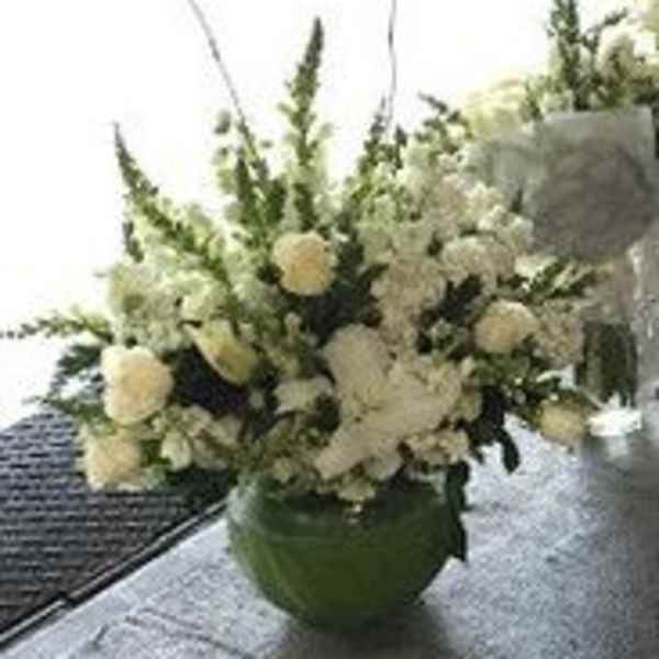 White floral arrangement in a green vase