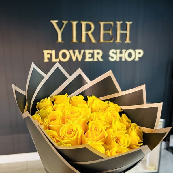 Bouquet of yellow roses wrapped in black paper with a yellow ribbon