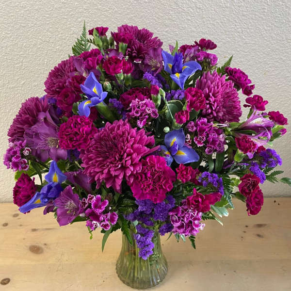 Bouquet of purple and blue flowers in a clear glass vase