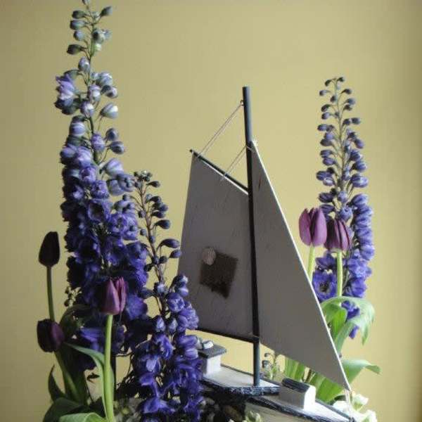 Sailboat-shaped floral arrangement with purple and white flowers