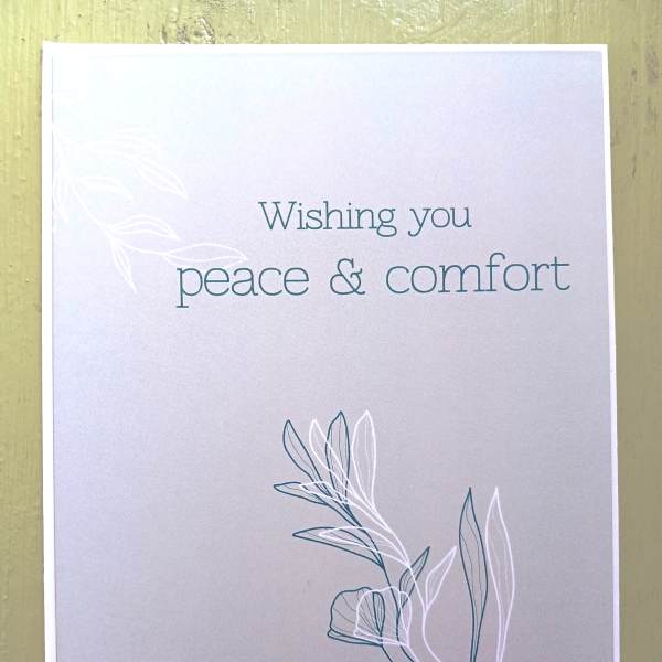 Sympathy greeting card with 'Wishing you peace & comfort' text and simple leaf line art on a soft gray background