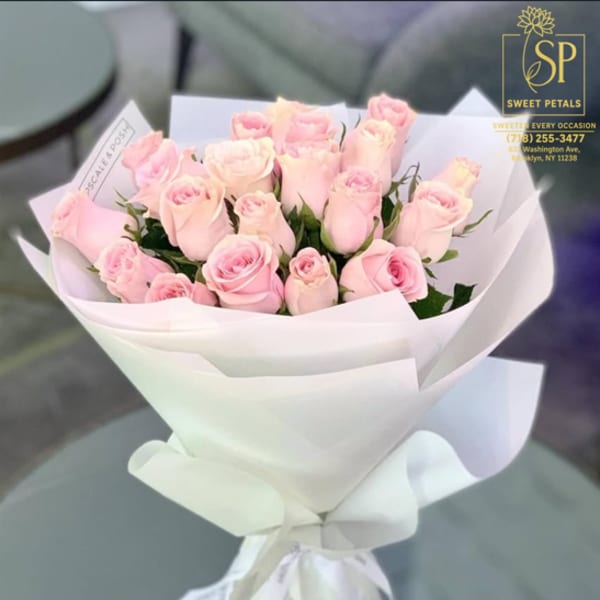 Bouquet of pale pink roses wrapped in white paper