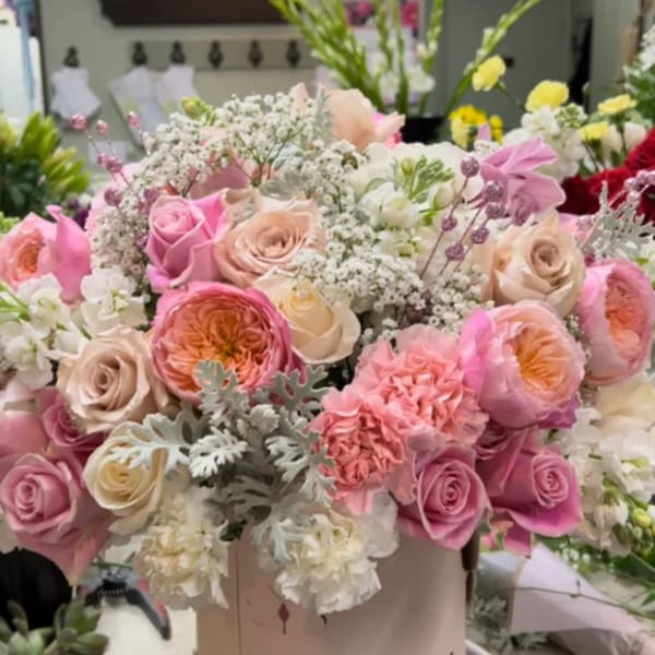Pink and cream rose bouquet in a round hatbox