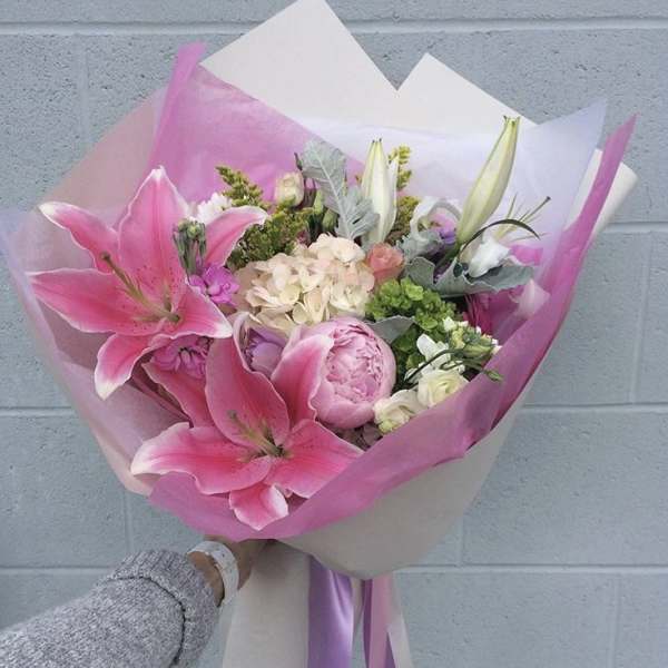 Pink lily and peony bouquet wrapped in pink and white paper