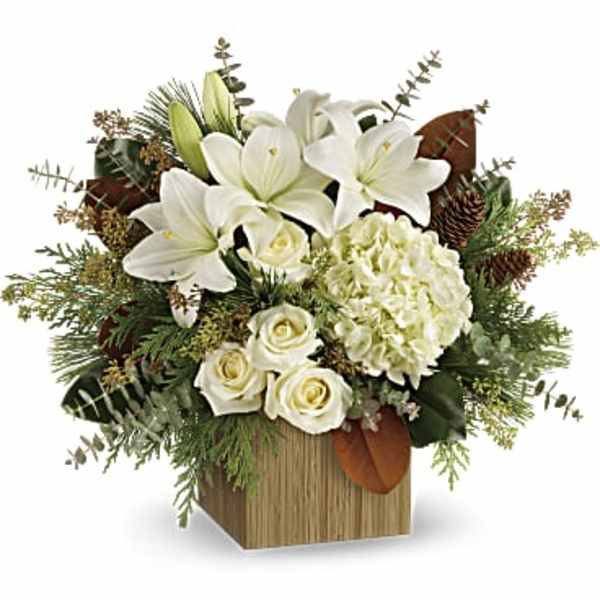 White lilies and roses in a wooden cube vase with greenery