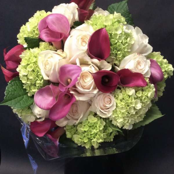 Bouquet of pink calla lilies, white roses, and green hydrangeas