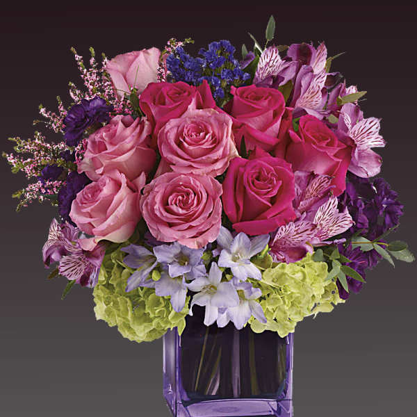 Pink and purple bouquet in a purple glass vase