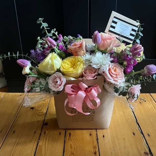 Mixed pastel flower arrangement in a square box with a pink ribbon