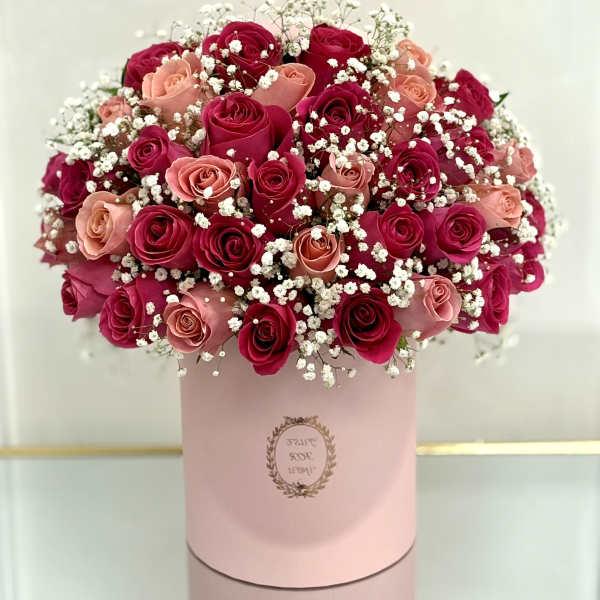 Bouquet of pink and red roses with baby's breath in a pink box
