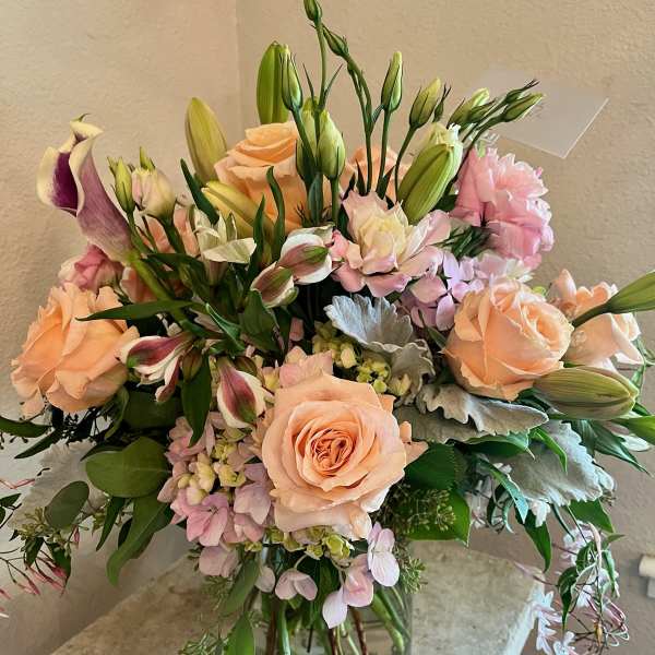 Peach roses and pink lilies in a glass vase
