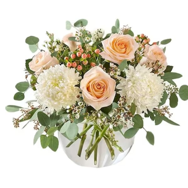 Peach roses and white mums in a white vase