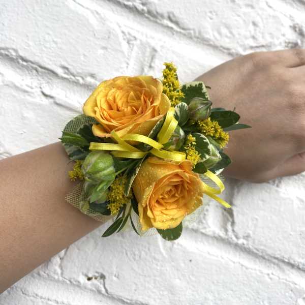 Yellow rose wrist corsage with ribbon and greenery