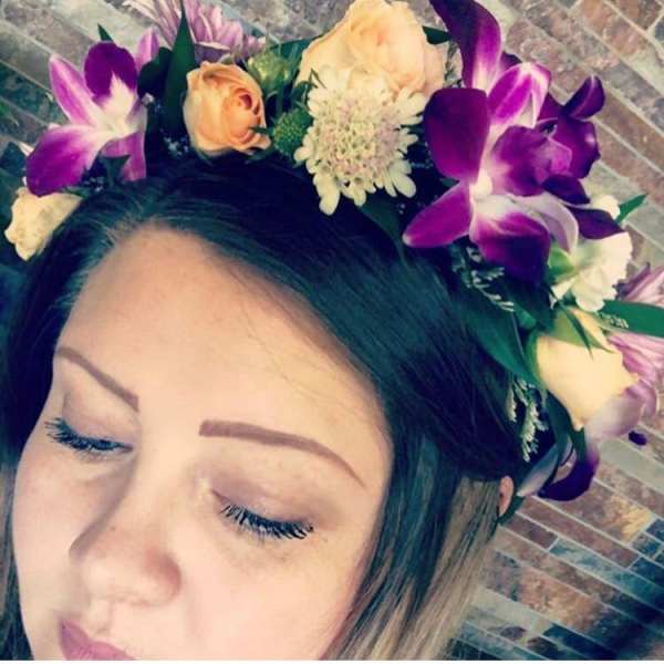 Woman wearing a floral crown with purple orchids and peach roses