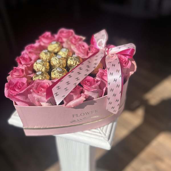 Pink rose arrangement with gold-wrapped chocolates in a pink box