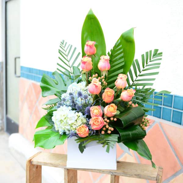 Tropical bouquet with pink roses and blue hydrangeas in a white box