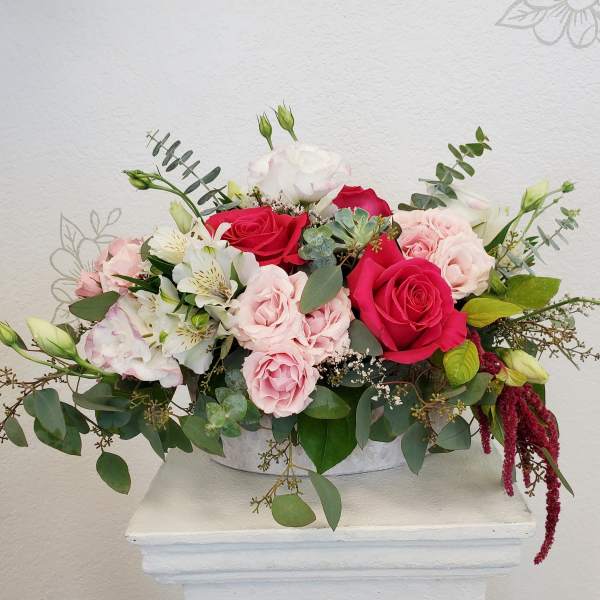 Pink and white rose arrangement in a low white container