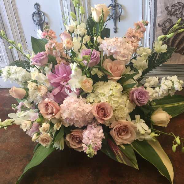 Large pastel floral arrangement with roses, hydrangeas, and lilies