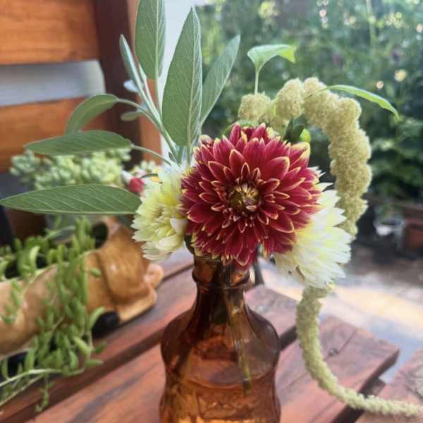 Dahlia bouquet in an amber glass vase with tall greenery