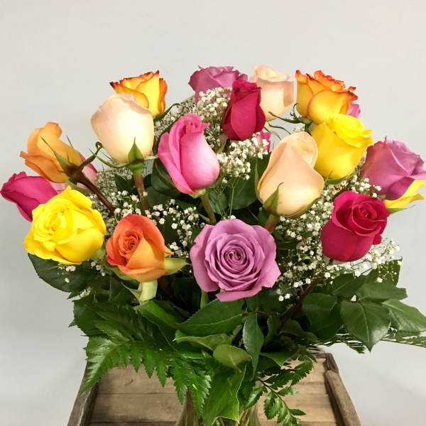 Mixed-color roses in a clear glass vase with baby's breath