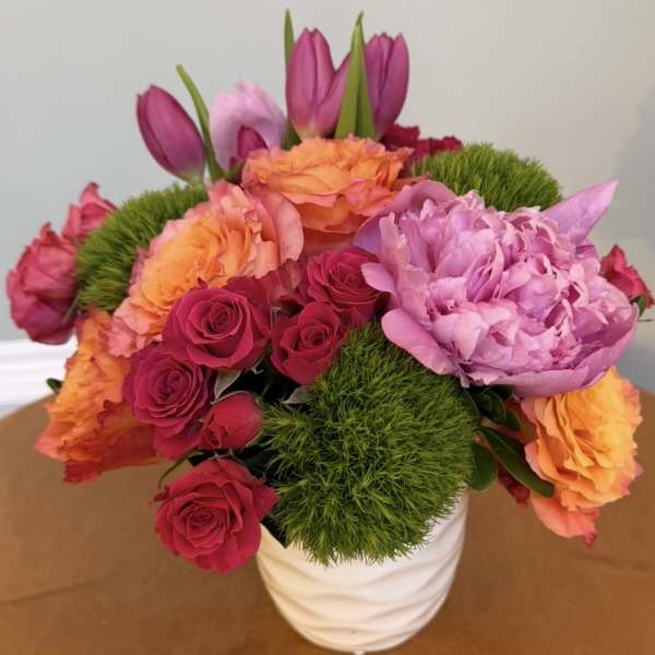 Bouquet of pink and orange flowers in a white vase