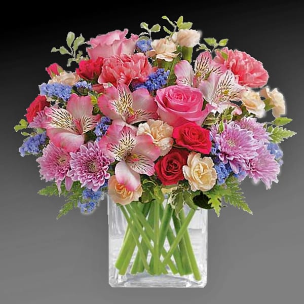 Mixed pink and red bouquet in a clear glass vase