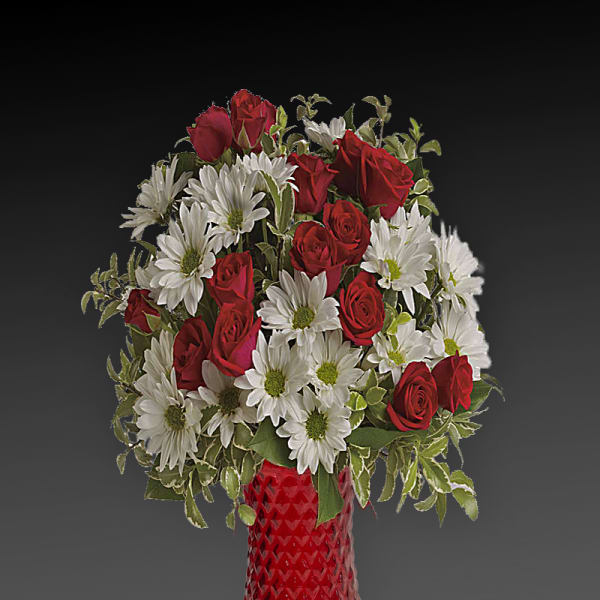 Red roses and white daisies arranged in a red glass vase