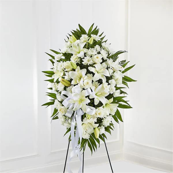 White floral standing spray on an easel with a ribbon