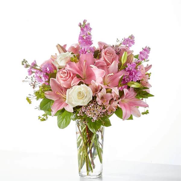 Pink and white bouquet of roses and lilies in a clear glass vase
