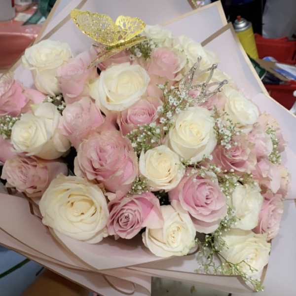 Bouquet of pink and white roses with decorative crown picks