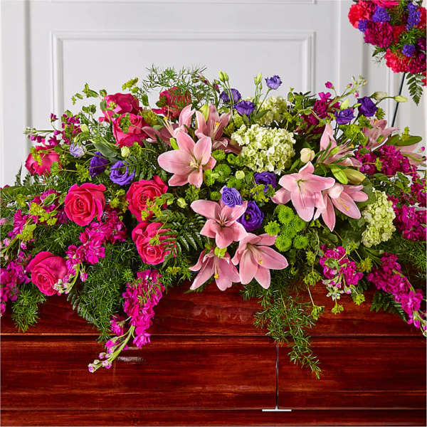 Large mixed floral arrangement with pink lilies, roses, and purple blooms