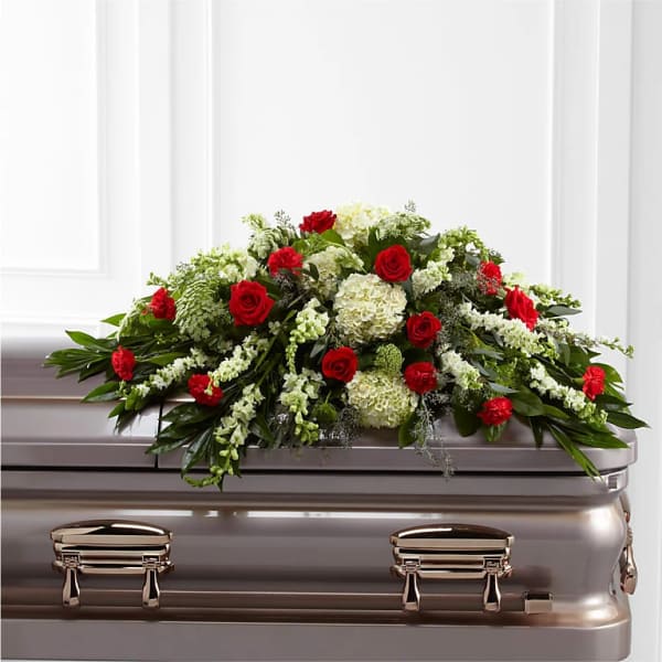 Red roses and white flowers arranged on a casket