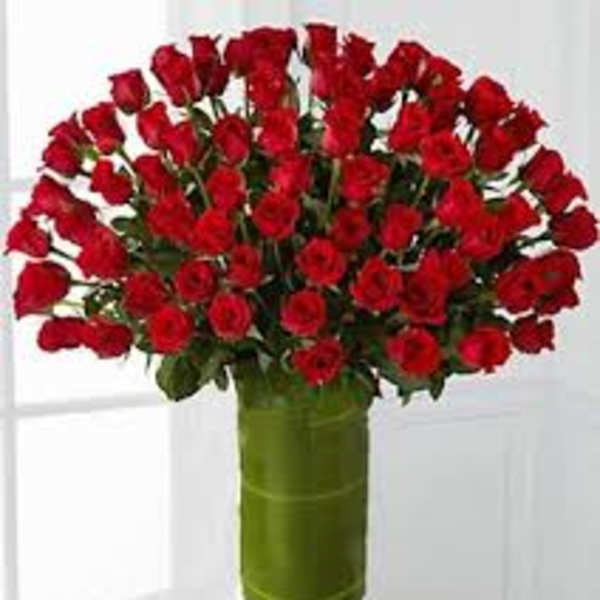 Bouquet of red roses in a tall green vase
