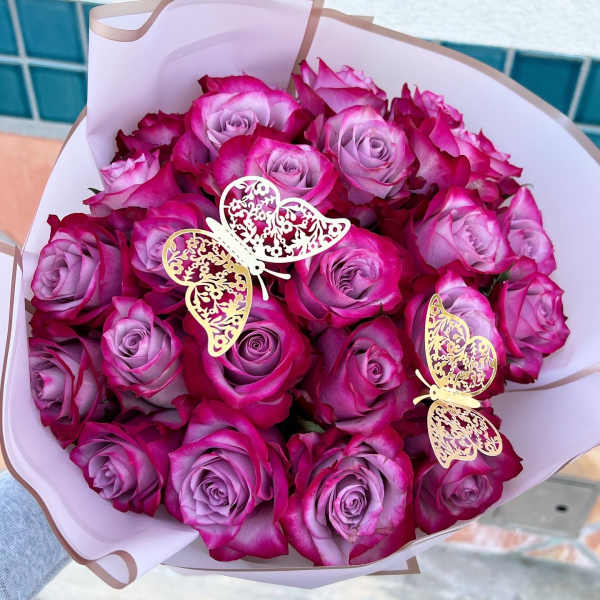 Bouquet of pink and lavender roses with butterfly decorations